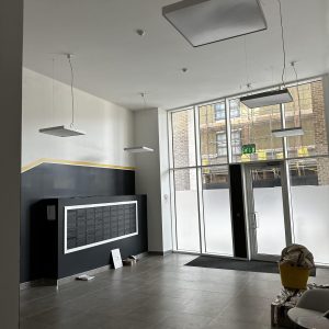 Contemporary property lobby with ceiling lights, glass entrance, and internal mailboxes.