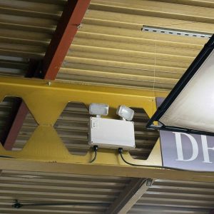Electrical junction box with wiring and lighting fixtures in a ceiling area.